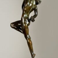 Alt text: Bronze sculpture of a nude woman skipping and holding a fish in one hand