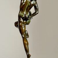 Alt text: Bronze sculpture of a nude woman skipping and holding a fish in one hand