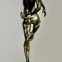 Alt text: Bronze sculpture of a nude woman skipping and holding a fish in one hand