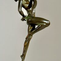 Alt text: Bronze sculpture of a nude woman skipping and holding a fish in one hand