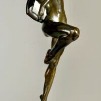 Alt text: Bronze sculpture of a nude woman skipping and holding a fish in one hand