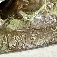 Alt text: Bronze sculpture, signature detail