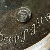 Alt text: Bronze sculpture, signature and foundry detail