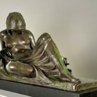 Alt text: Bronze sculpture of a reclining woman