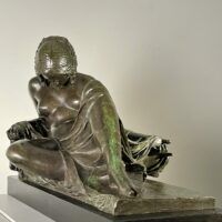 Alt text: Bronze sculpture of a reclining woman