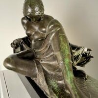 Alt text: Bronze sculpture of a reclining woman