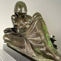 Alt text: Bronze sculpture of a reclining woman