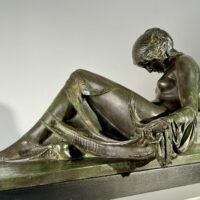 Alt text: Bronze sculpture of a reclining woman