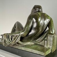 Alt text: Bronze sculpture of a reclining woman