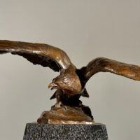 Alt text: Bronze sculpture of an eagle with wings spread