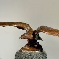 Alt text: Bronze sculpture of an eagle with wings spread