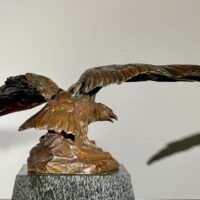 Alt text: Bronze sculpture of an eagle with wings spread