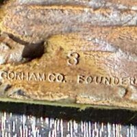 Alt text: Bronze sculpture, foundry mark detail