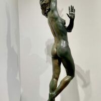 Alt text: Bronze sculpture of a woman standing on a wave