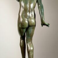 Alt text: Bronze sculpture of a young nude woman standing among frogs