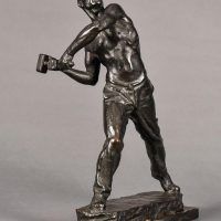 Alt text: Bronze sculpture of a muscular shirtless man swinging a hammer