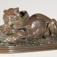 Alt text: Bronze sculpture of a tiger eating a gavial