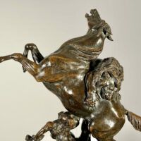 Alt text: Bronze sculpture of a lion attacking a horse