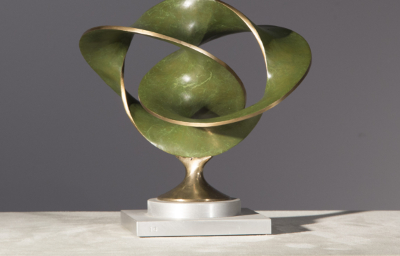Alt text: Abstract bronze sculpture of three distorted and conjoined circles