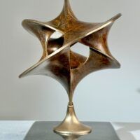 Alt text: Geometric bronze sculpture with brown patina