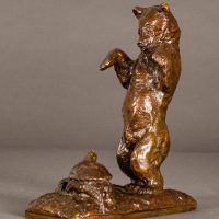 Alt text: Bronze sculpture of a bear standing on his hind legs scaring a turtle, angled view