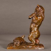 Alt text: Bronze sculpture of a bear standing on his hind legs scaring a turtle, side view