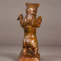 Alt text: Bronze sculpture of a bear standing on his hind legs scaring a turtle, rear view