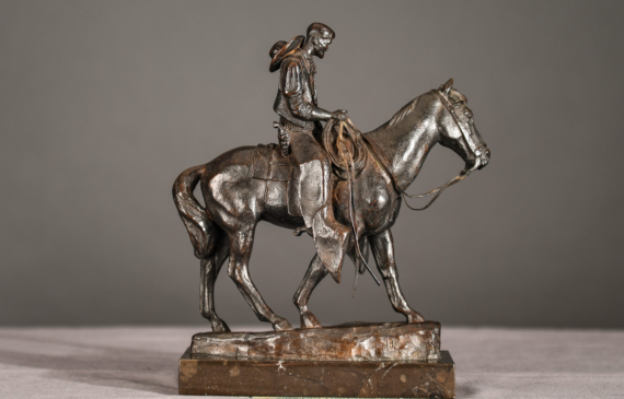 Alt text: Bronze sculpture of a cowboy riding on a horse