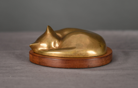 Bronze sculpture of a sleeping cat curled up