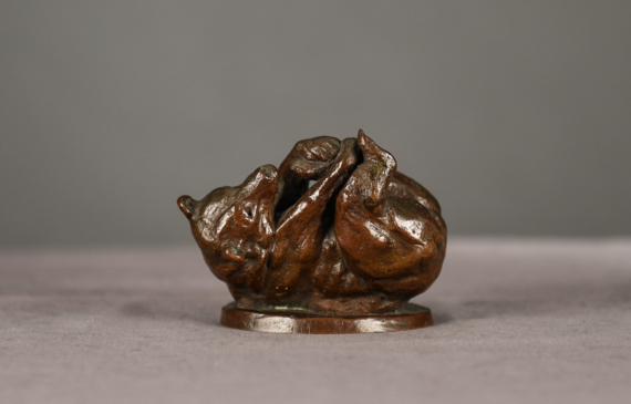 Alt text: Bronze sculpture of a bear on his back holding his feet