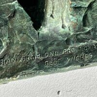 Alt text: Signature detail of a bronze sculpture of an American Indian on horseback 