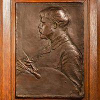 Alt text: Bronze bas relief of Jules Bastian LePage with paintbrush and palette, framed