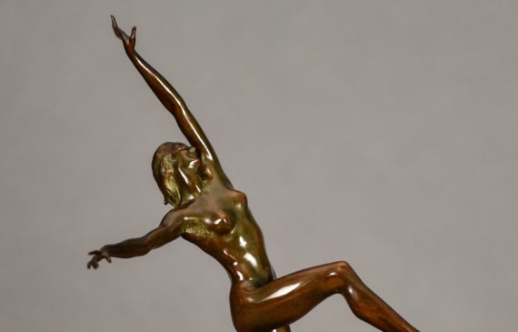 Alt text: Bronze sculpture of a nude woman posing with arms outstretched in an L shape and right leg lifted with knee bent