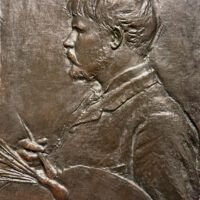 Alt text: Bronze bas relief of a man in profile with a paintbrush and palette