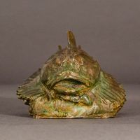 Alt text: Bronze sculpture of a sculpin fish atop the water, frontal view