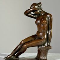 Alt text: Bronze sculpture of a nude figure seated with a hand over her eyes