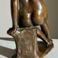 Alt text: Bronze sculpture of a nude figure, detail
