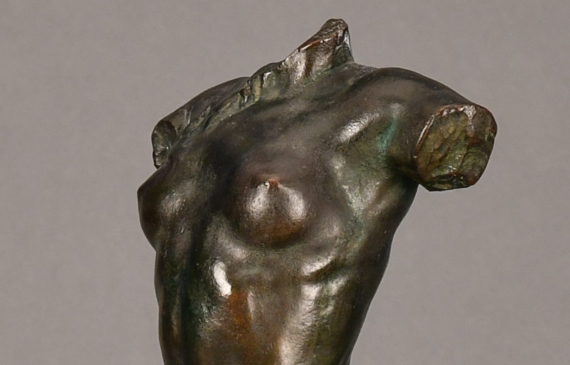Alt text: Bronze sculpture of a headless and armless seated female nude