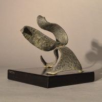 Alt text: Abstract soldered lead sculpture atop a wooden base resembling a swan, angled view