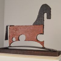 Alt text: Painted, welded steel sculpture of a horse, angled view