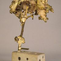 Alt text: Welded bronze sculpture shaped like a tree mounted on a slag block, angled view