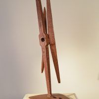 Alt text: Welded pickaxe sculpture resembling a propeller, angled view