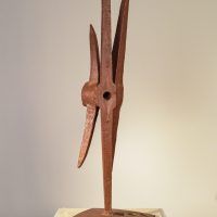 Alt text: Welded pickaxe sculpture resembling a propeller, angled view