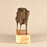 Alt text: Bronze modernist sculpture of a bull atop a marble base