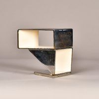 Alt text: Abstract sculpture made of steel and enamel with two geometric shapes fused together