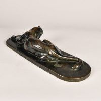 Alt text: Bronze sculpture of a lounging puma grooming itself