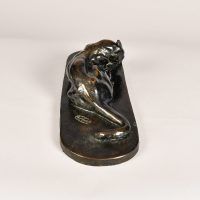 Alt text: Bronze sculpture of a lounging puma grooming itself