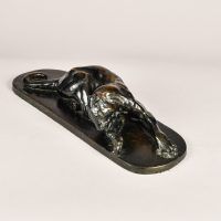 Alt text: Bronze sculpture of a lounging puma grooming itself