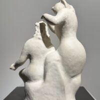 Alt text: White sculpture of two women, one standing and one seated