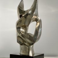 Alt text: Polished bronze sculpture of an abstract cat head, angle view